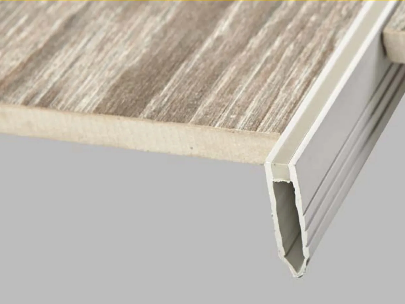 Nez de marche aluminium posé sur une marche carrelée